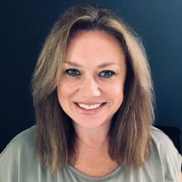 Headshot of woman in sage green top smiling at camera.