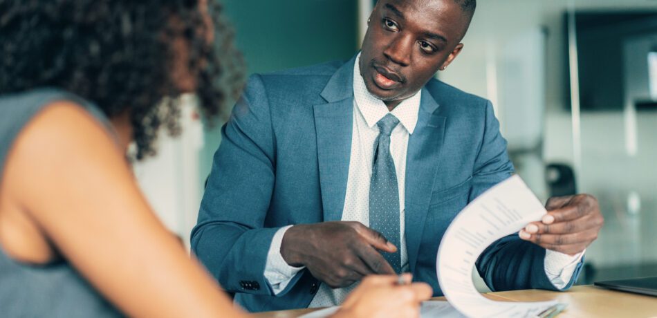 an insurance underwriter meeting with a woman in an office