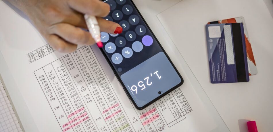 Woman using a calculator to go over bills.