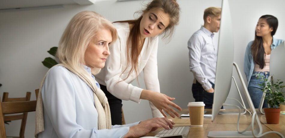 Younger employee speaking down to an older woman employee.