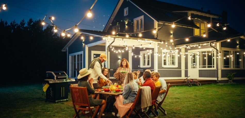 Multigenerational and multiethnic families enjoying dinner outside.