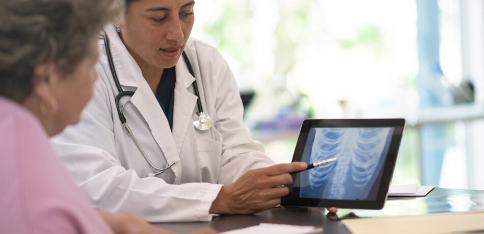 Older woman receiving and reviewing her x-ray results from the doctor.