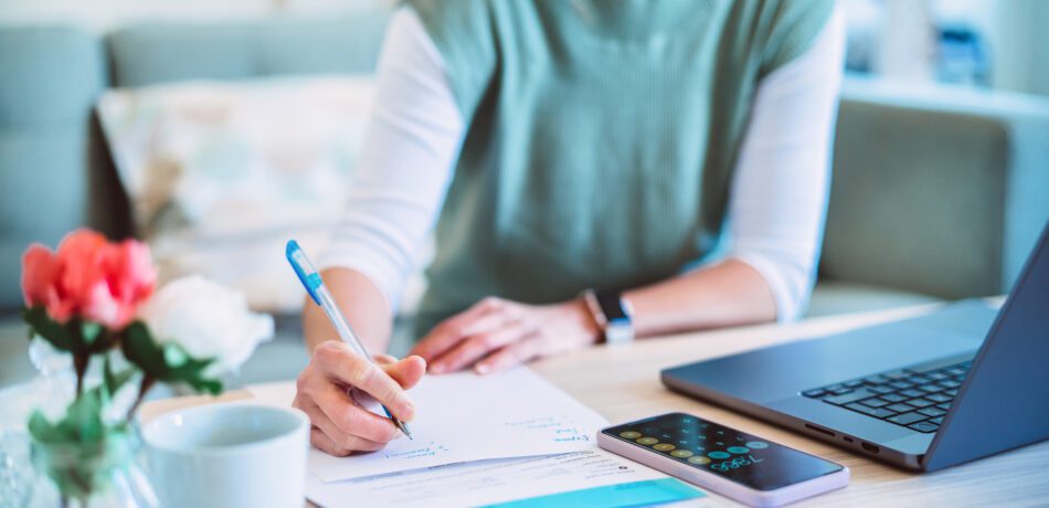 Woman at laptop at home managing her money.